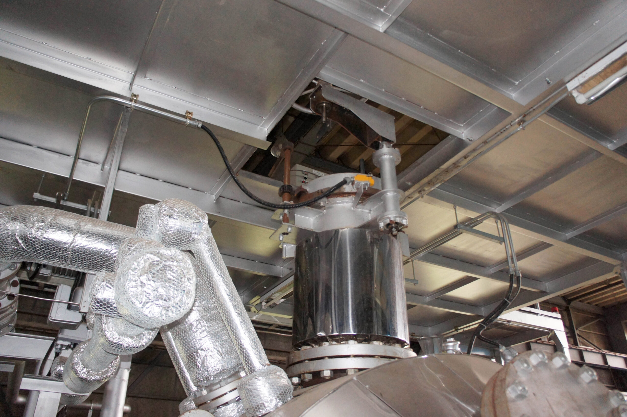 Industrial piping and insulated machinery inside a factory facility