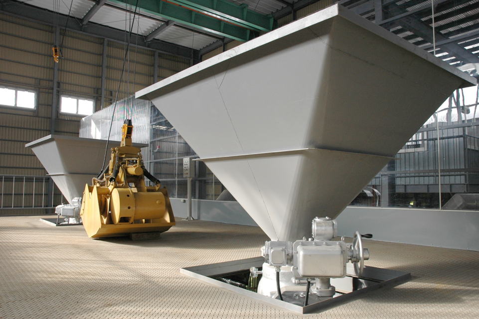 Large industrial hoppers and mechanical equipment inside a factory facility